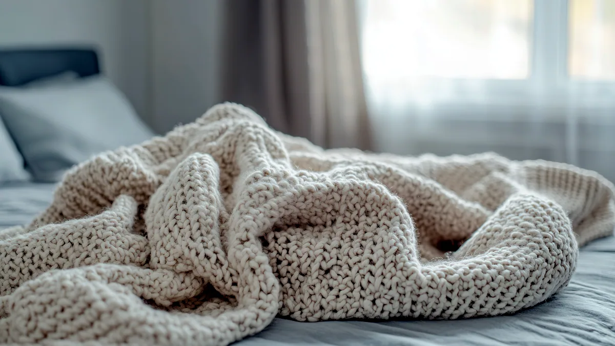 A soft angora blanket draped over a bed corner, its pile catching warm light.