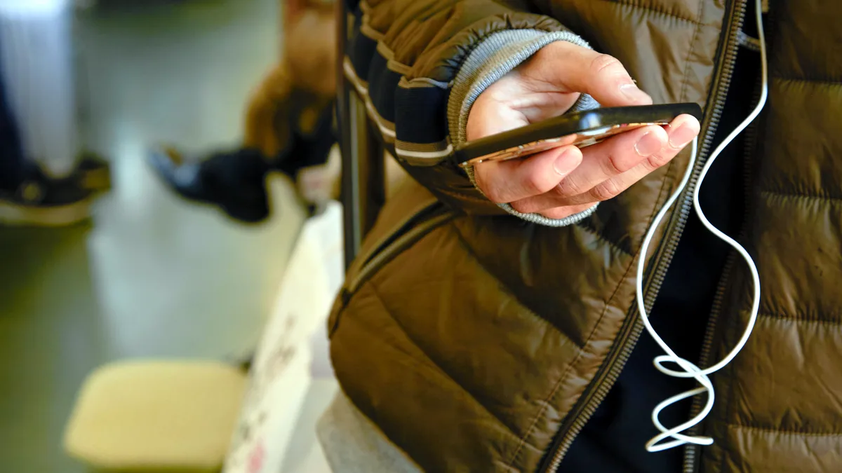 A heated thermal garment with a small battery control panel at the chest.