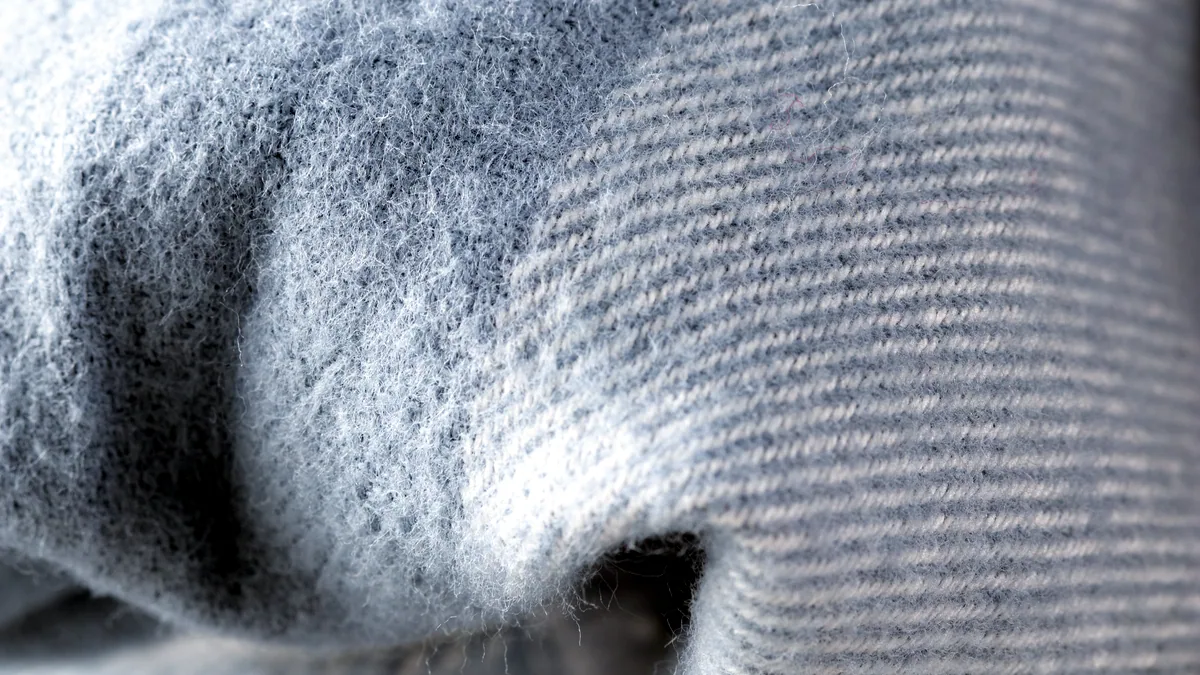 A pale merino base layer stretched out to show the fine knit structure.