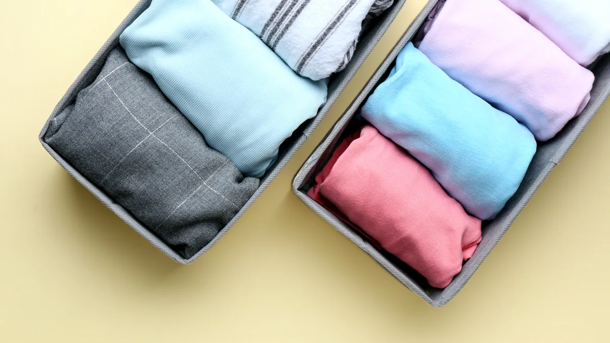 A neat stack of folded thermal underwear in grey and navy tones.